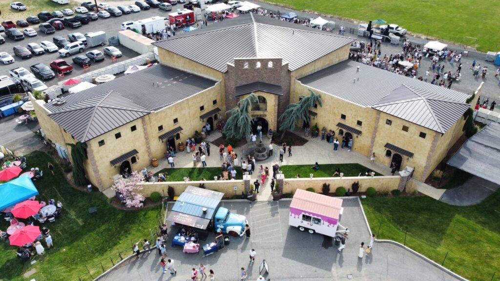 Aerial view of event at modern building with food trucks.
