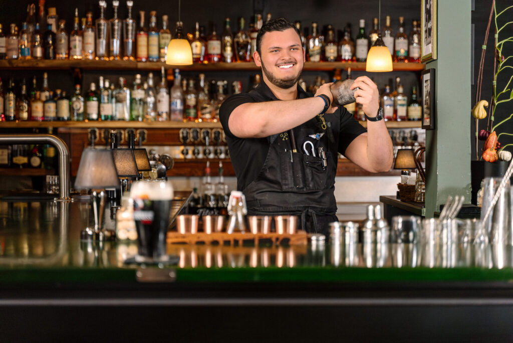 Bartender shaking cocktail behind bar counter