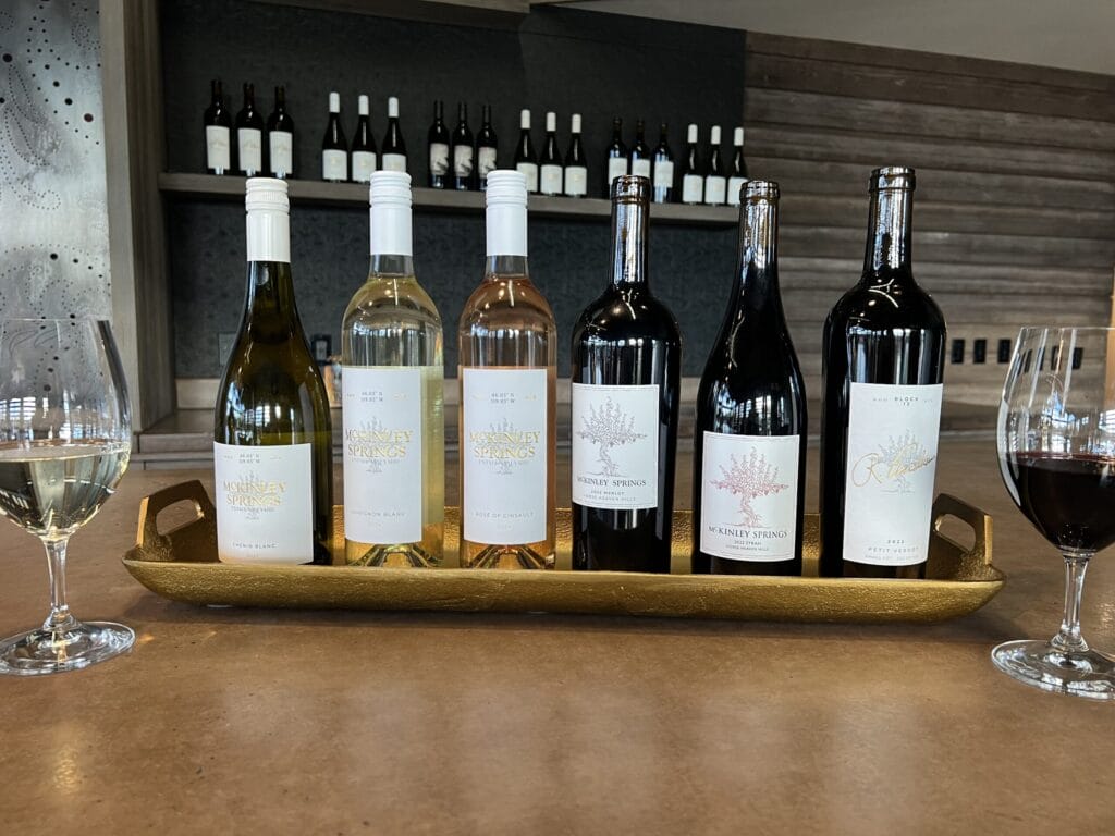 Assorted wine bottles on a table with glasses