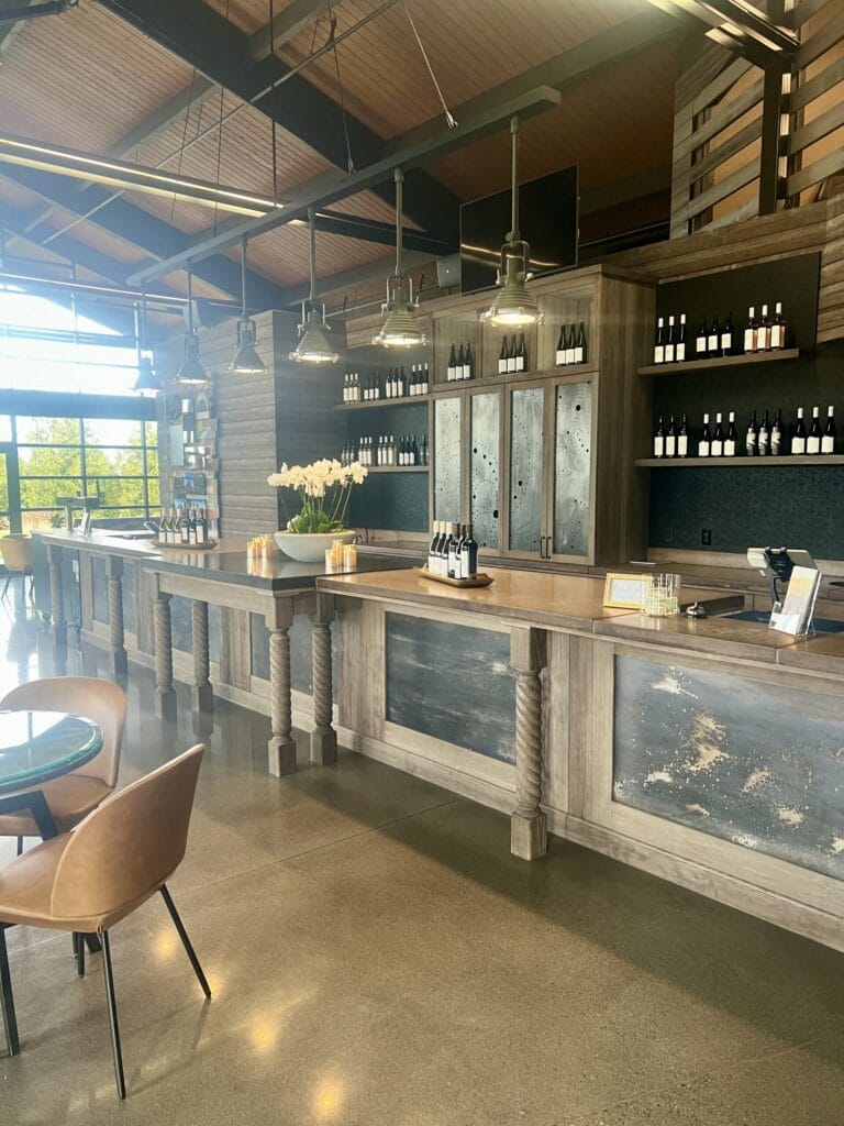 Modern winery tasting room with wine bottles displayed.