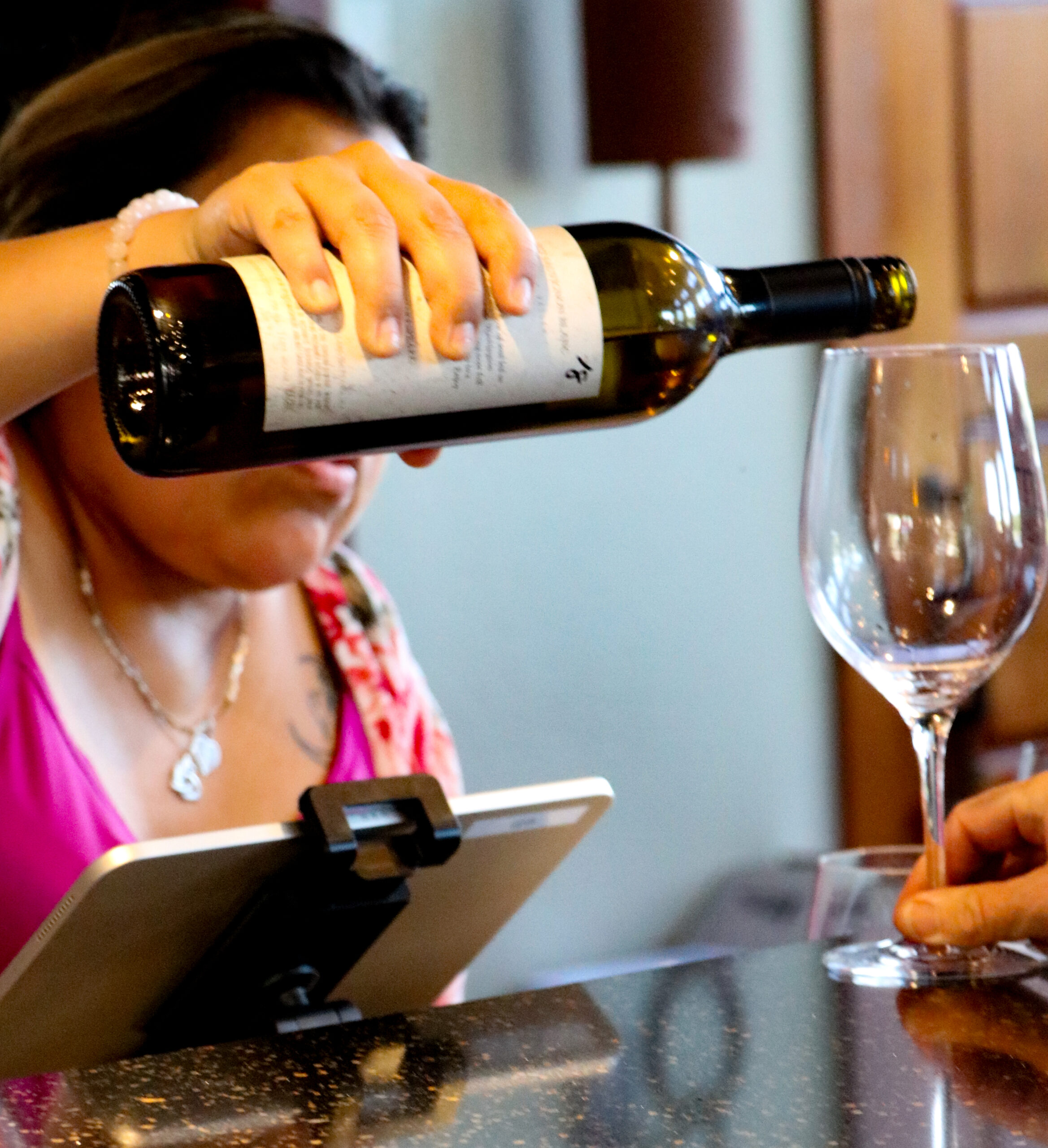 Person pouring white wine into a glass
