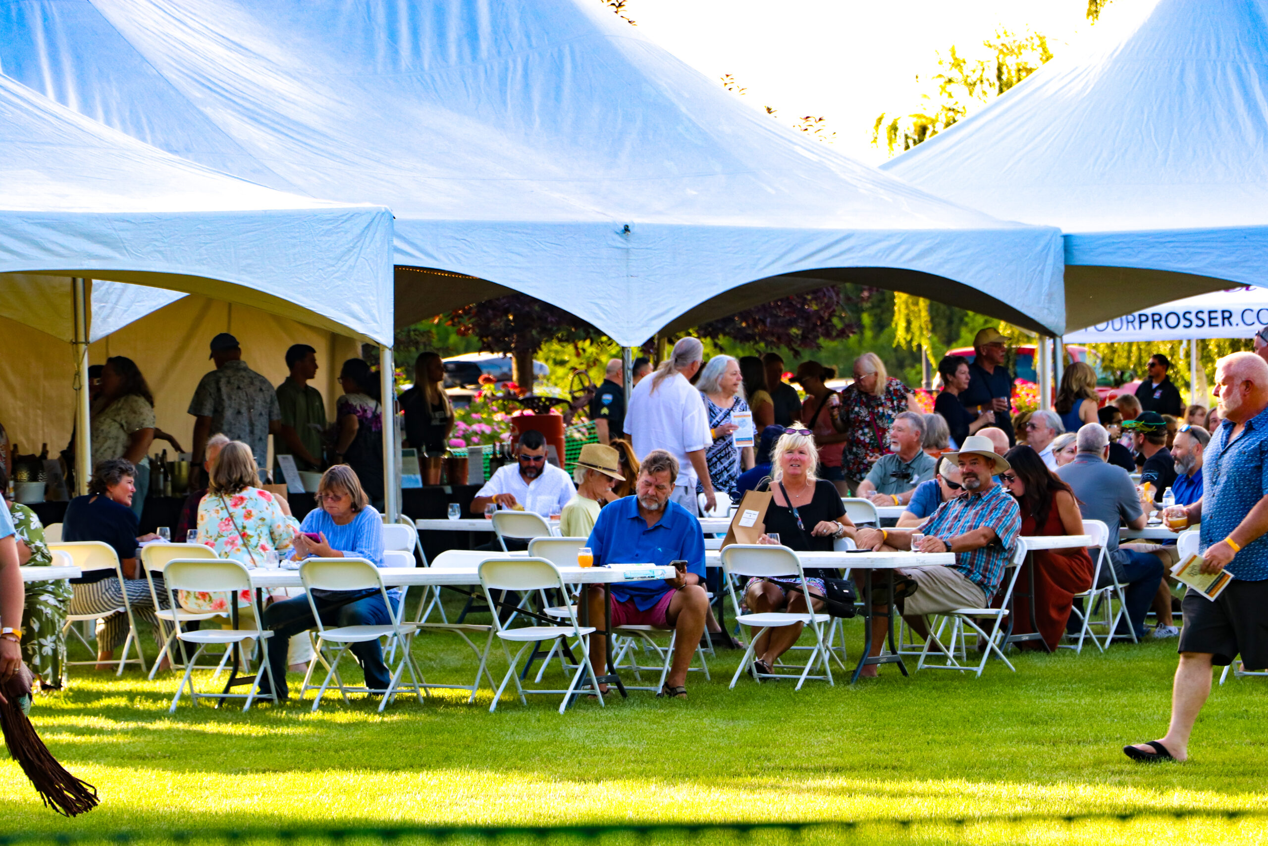 Outdoor festival with people eating under tents