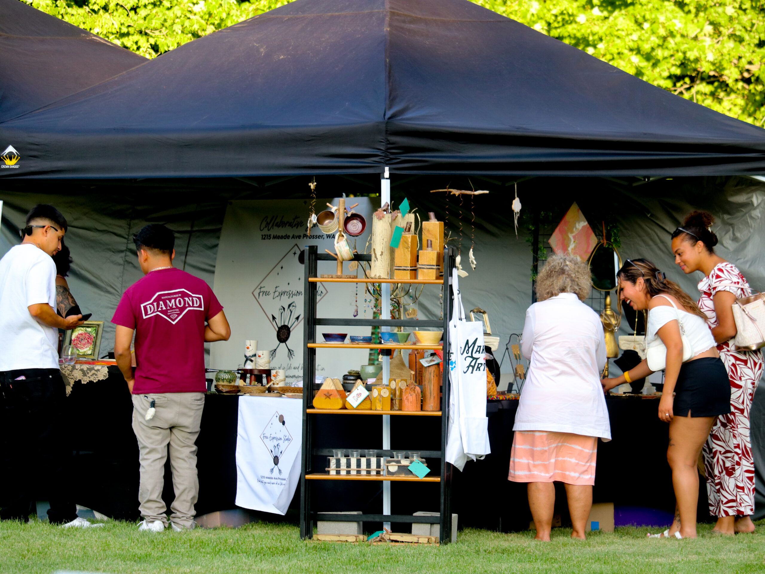 People shopping at outdoor craft market stall