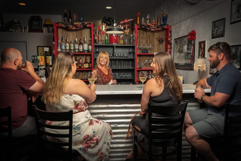 People enjoying drinks at a bar with bartender.