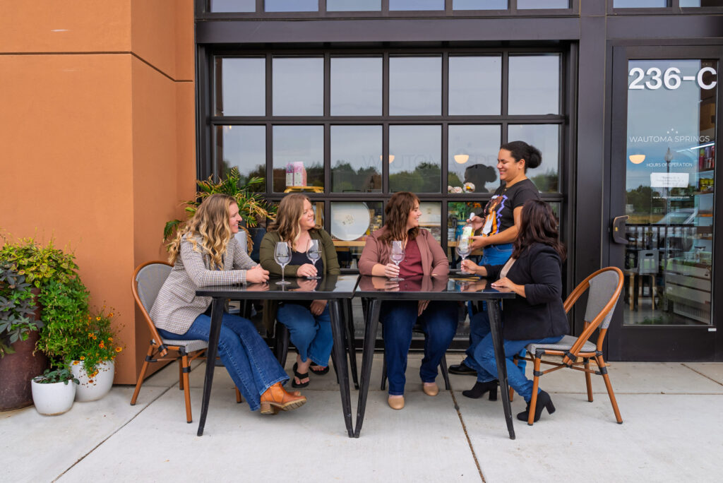 Group enjoying wine at outdoor cafe.