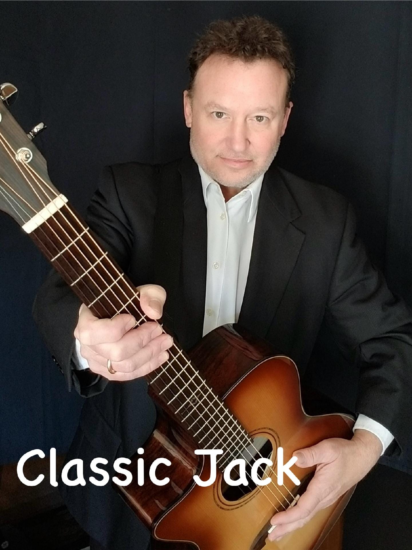 Man in suit holding acoustic guitar