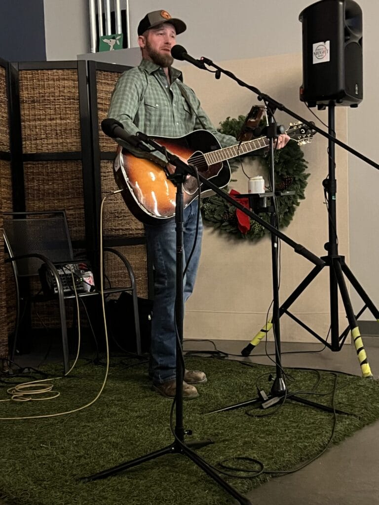Man performing music with guitar and microphone