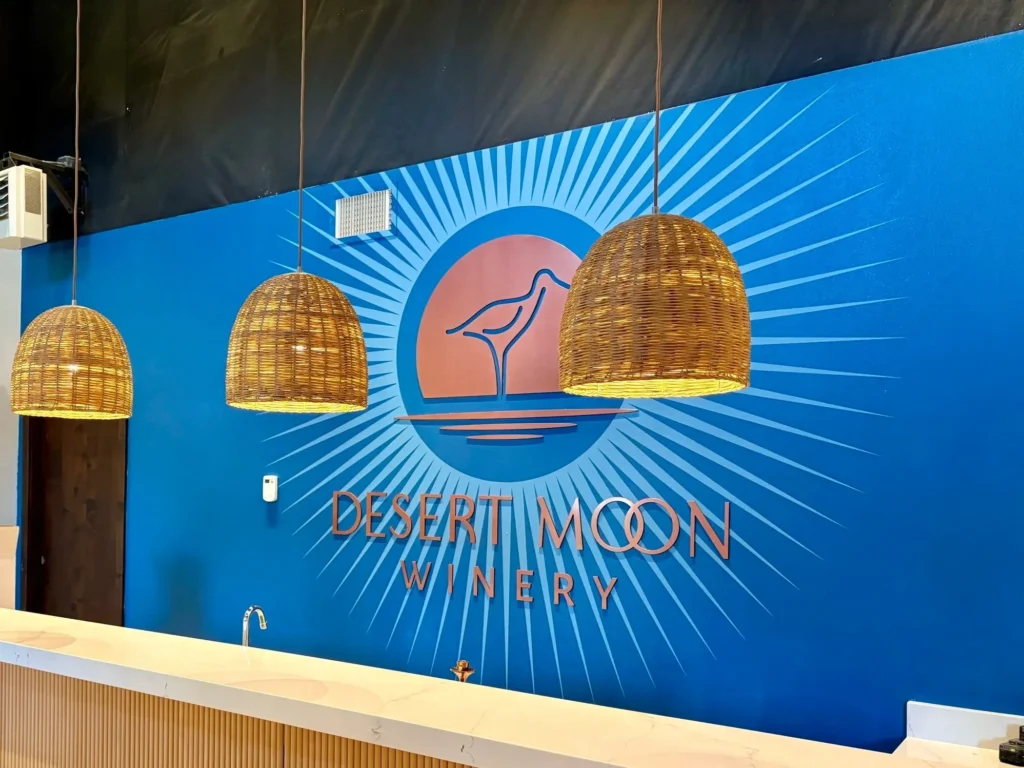 Desert Moon Winery logo on blue wall.