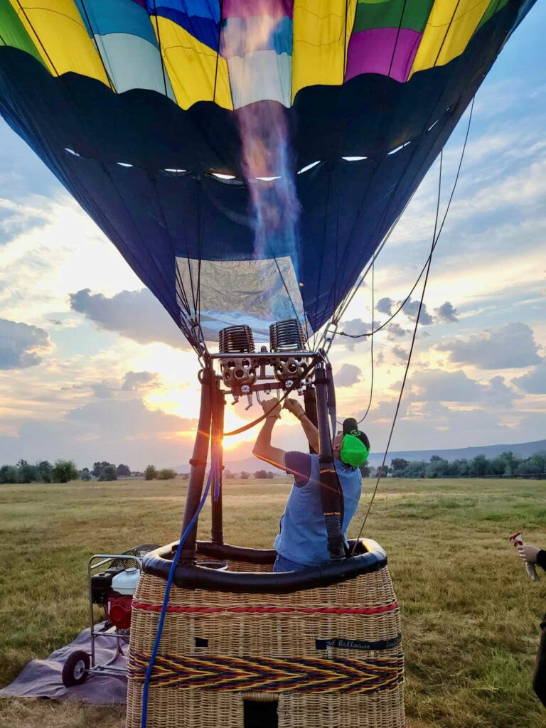Hot air balloon preparing for launch at sunset.