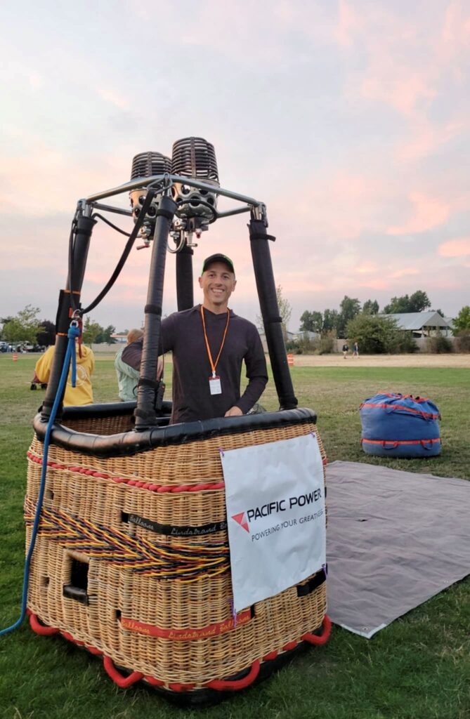 Man in hot air balloon basket at event.