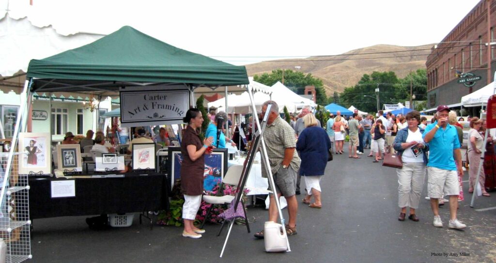 Art and framing booth at outdoor festival.