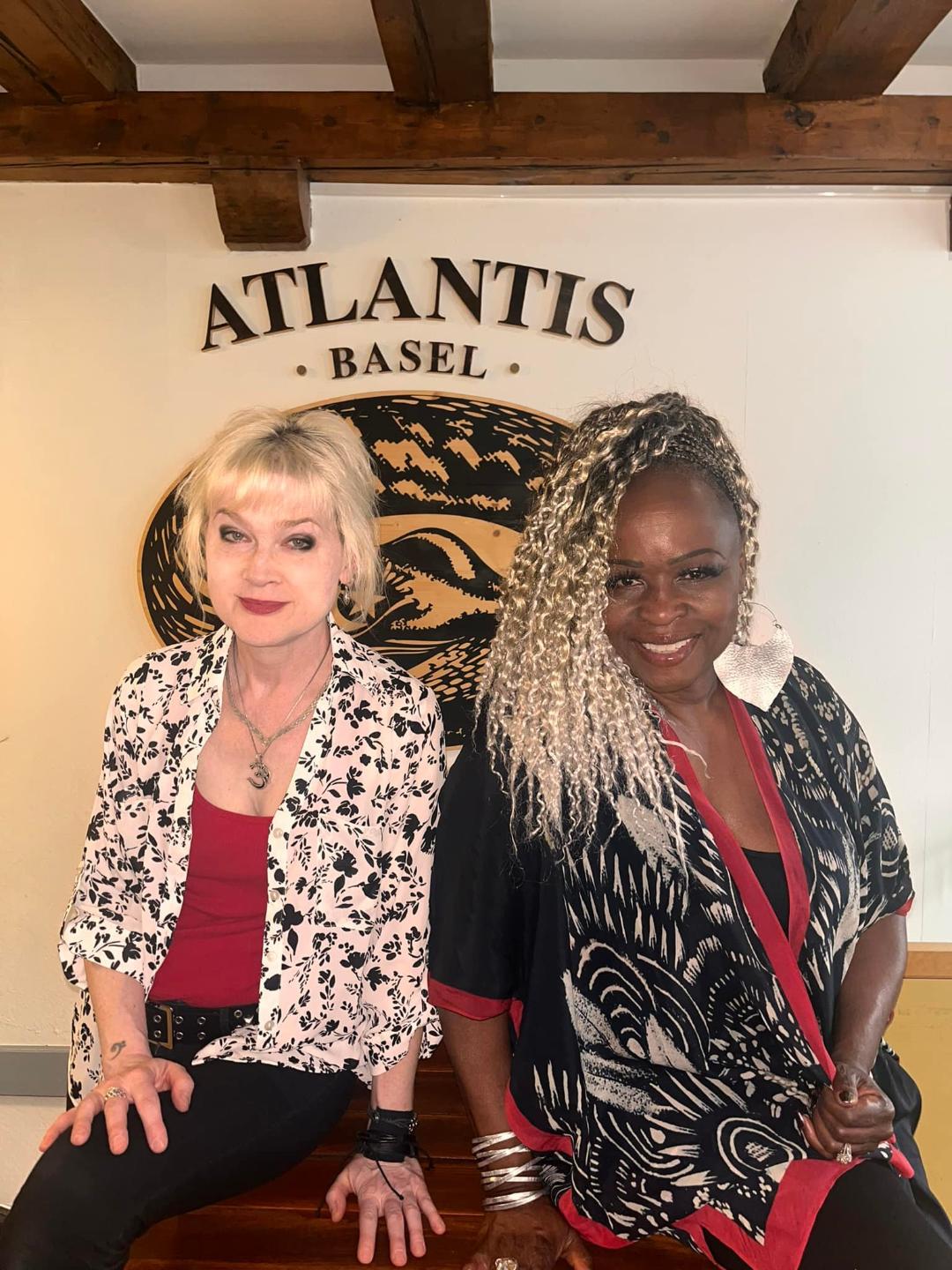 Two women posing at Atlantis Basel restaurant.