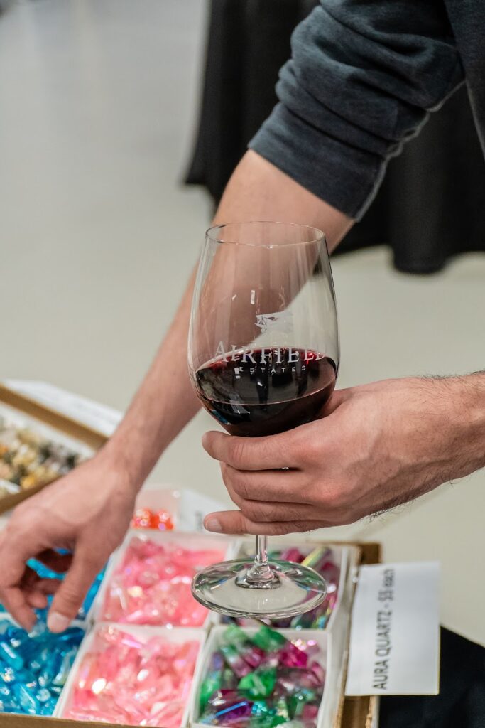 Hand holding a wine glass over candies.
