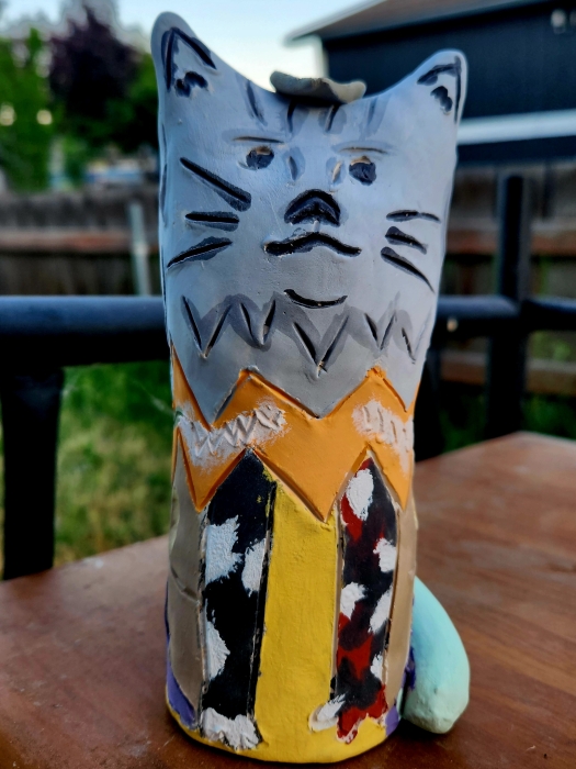 Handmade painted cat sculpture on outdoor table