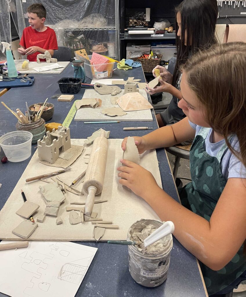 Children sculpting clay in art classroom