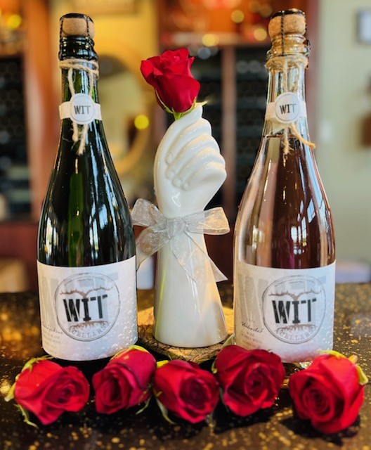 Two WIT wine bottles with roses and ceramic rose vase