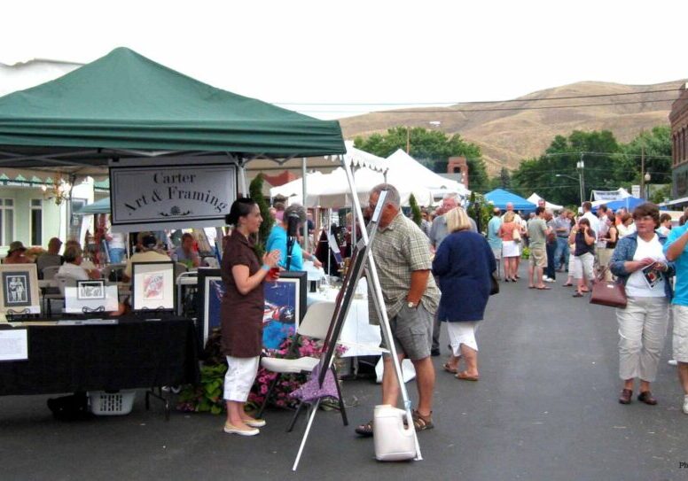 Art and framing booth at outdoor festival.