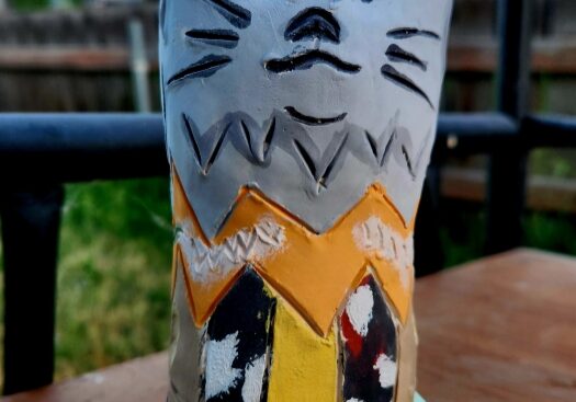 Handmade painted cat sculpture on outdoor table
