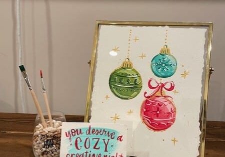 Framed Christmas ornaments art with paintbrushes.
