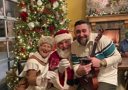 Festive gathering by Christmas tree with Santa and guitar.