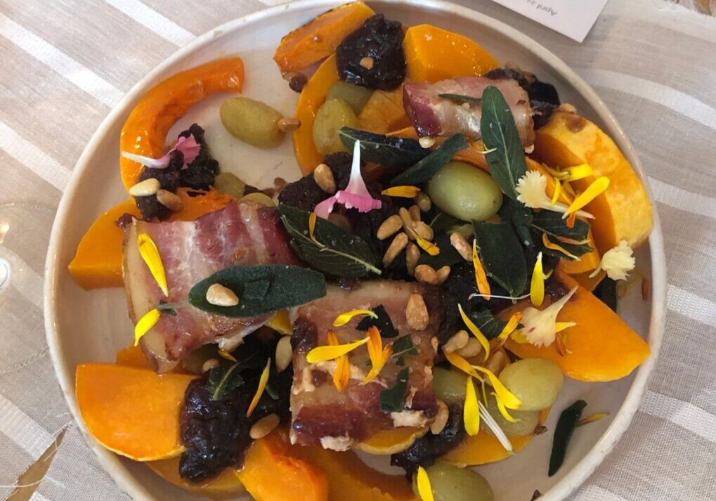 Colorful autumn salad with bacon and edible flowers.