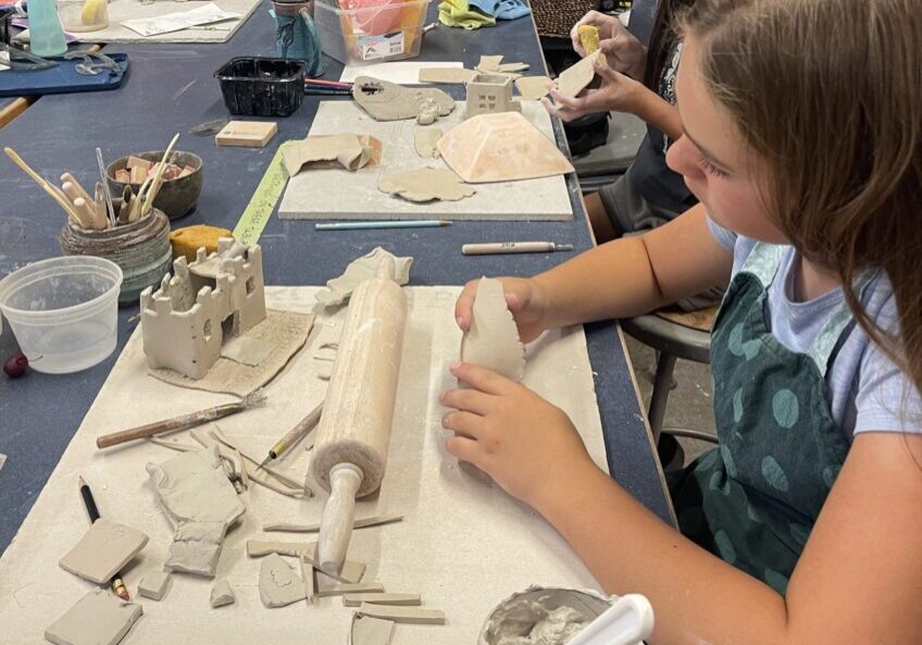 Children sculpting clay in art classroom