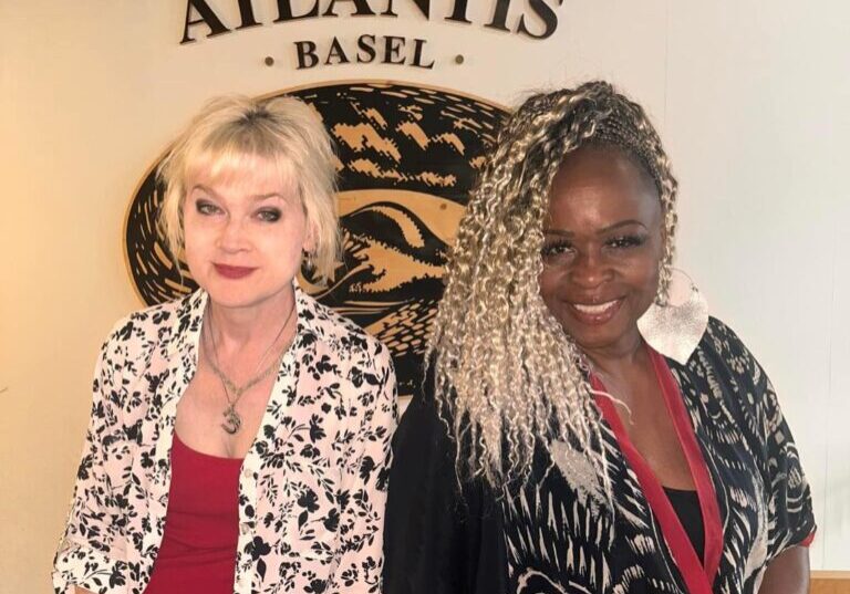 Two women posing at Atlantis Basel restaurant.