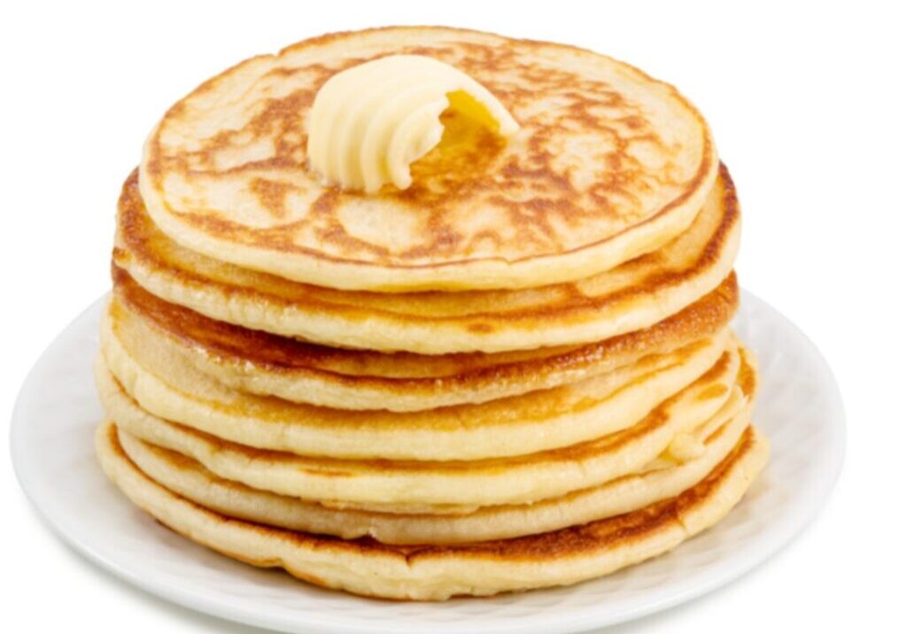 Stack of pancakes with butter on white plate.