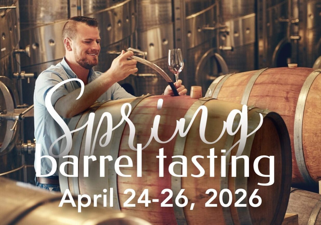 Man sampling wine from barrels at spring event.